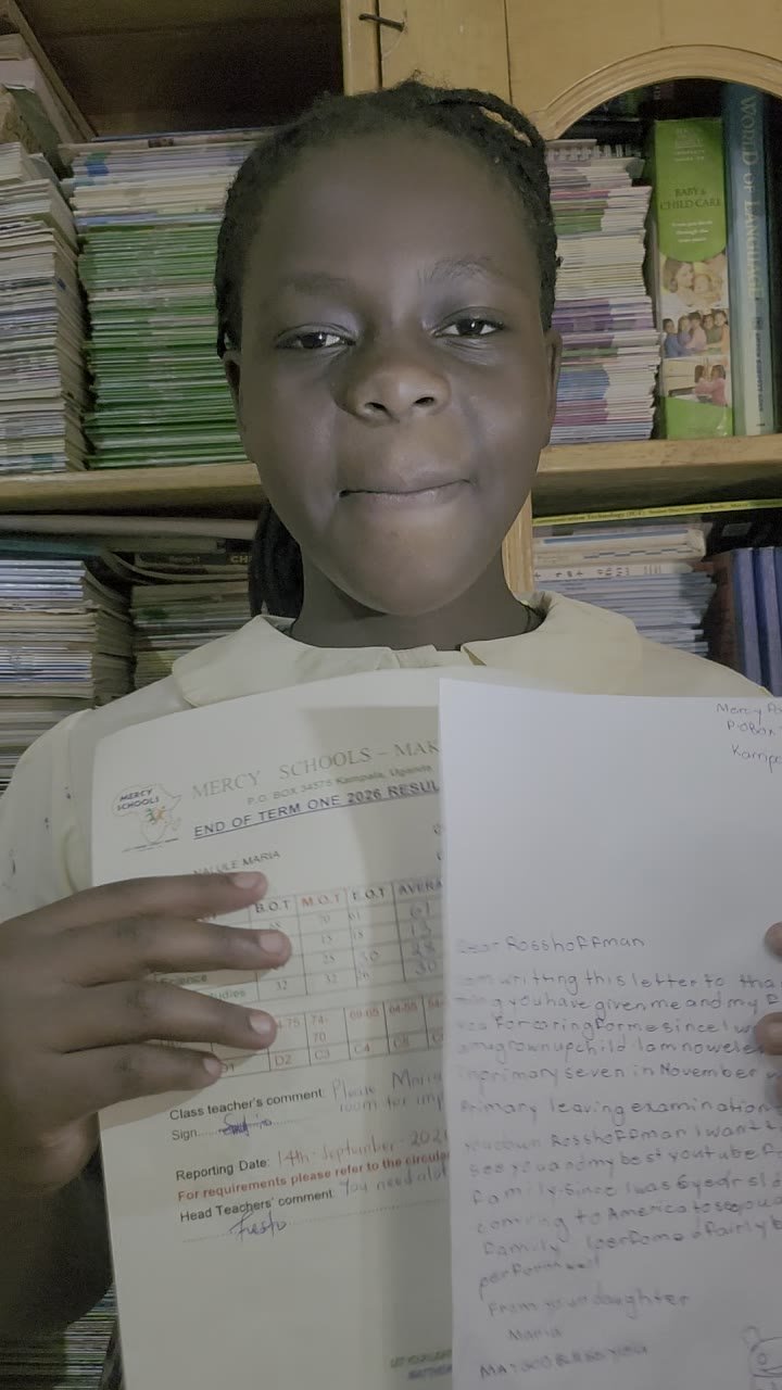 A Mercy Schools pupil holds her report card and a handwritten thank-you letter